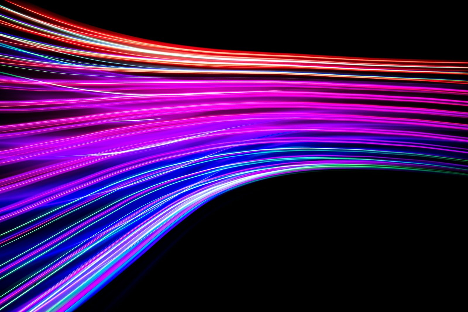 Faisceaux de lumière magenta et violets filant dans le noir