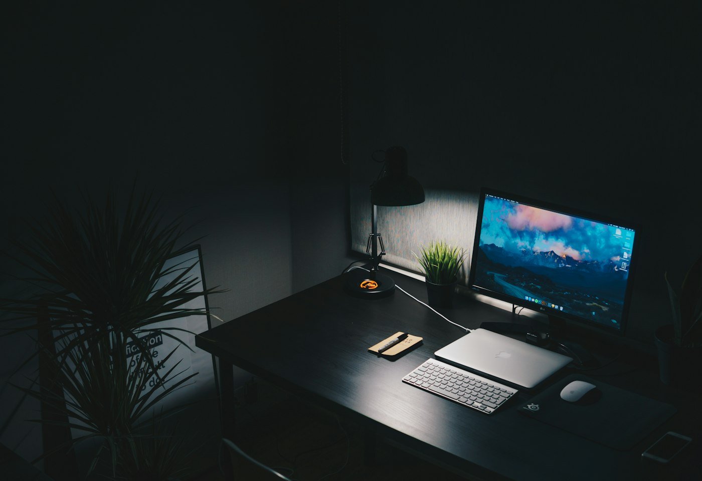 Poste de travail allumé sur un bureau dans la pénombre
